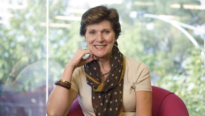 Barbara Hocking sitting with her chin resting on her hand and smiling