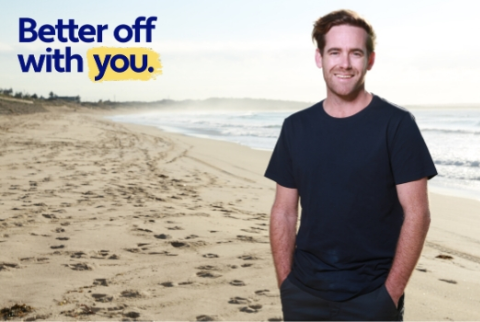 Better off with you campaign - man standing on beach with hands in pockets